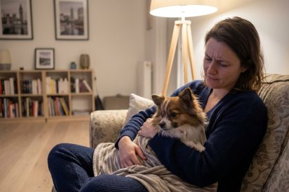 Jeune femme inquiète avec son chien dans un salon moderne
